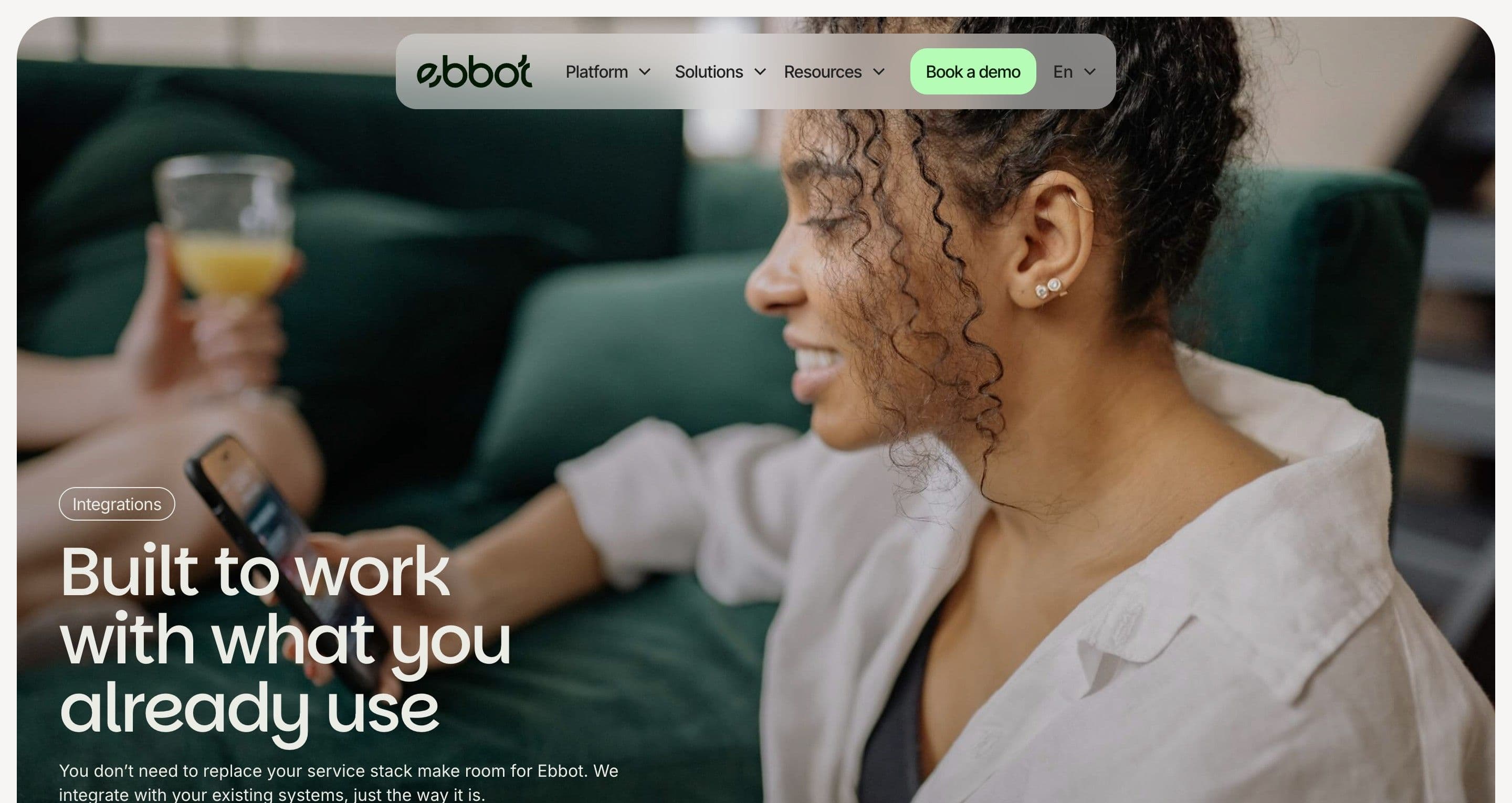 The integrations page on ebbot.com, a full-bleed photo of a smiling woman on her phone behind the headline